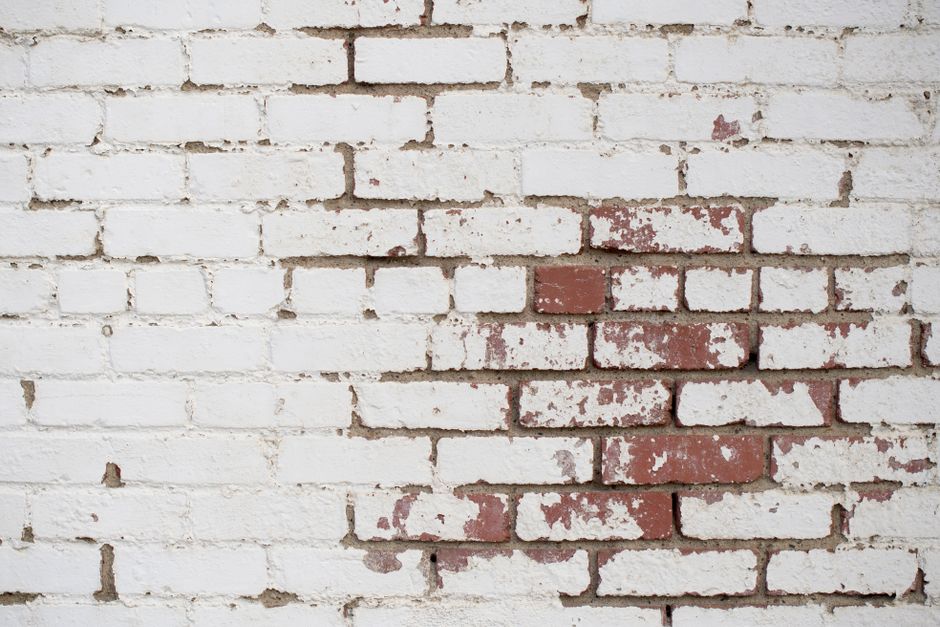 Professional mason performing detailed brick repointing and mortar restoration